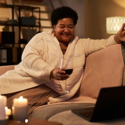 Senior Black Woman Talking via Video Chat with Wine